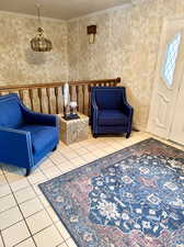 Living area featuring ornamental molding and tile patterned flooring