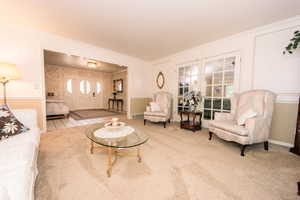 Carpeted living room featuring crown molding and a healthy amount of sunlight