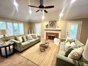 Living room with ceiling fan, lofted ceiling, a wealth of natural light, and a tile fireplace