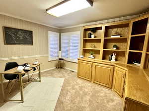 Office area with crown molding and light carpet