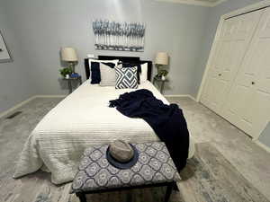 Carpeted bedroom featuring a closet and crown molding