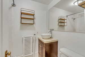 Bathroom featuring a shower, toilet, and vanity