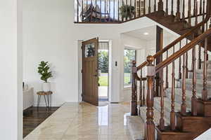 Entrance foyer featuring a towering ceiling and hardwood / wood-style flooring