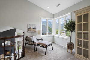 Sitting room featuring carpet flooring and vaulted ceiling