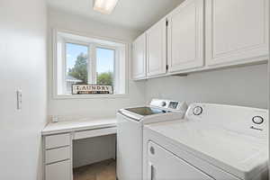 Laundry room with light tile patterned floors, cabinets, and washing machine and clothes dryer