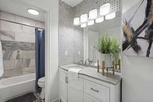 Full bathroom featuring vanity, toilet, and shower / tub combo