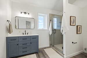 Bathroom featuring walk in shower, hardwood / wood-style flooring, and vanity