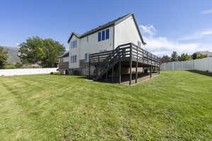 Rear view of property featuring a yard and a deck