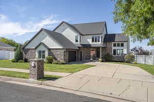 View of front of home with a garage and a front lawn