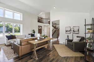 Living room with high vaulted ceiling and dark hardwood / wood-style floors