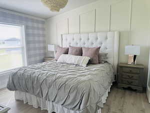 Bedroom with wood finished floors and multiple windows