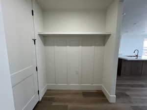 Mudroom with baseboards, a sink, and wood finished floors