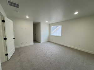 Empty room featuring carpet flooring, recessed lighting, baseboards, and visible vents