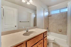 Full bathroom with shower / bath combo with shower curtain, tile patterned floors, toilet, and vanity