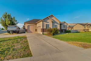 View of front facade featuring a garage and a front yard