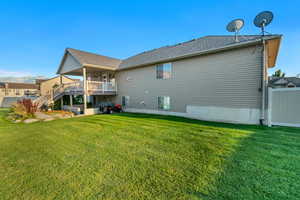 Rear view of property featuring a yard and a wooden deck