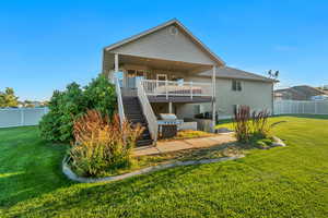 Rear view of property featuring a lawn and a wooden deck