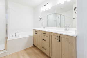 Bathroom featuring hardwood / wood-style floors, vanity, and separate shower and tub