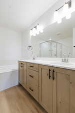 Bathroom with vanity, separate shower and tub, and hardwood / wood-style flooring