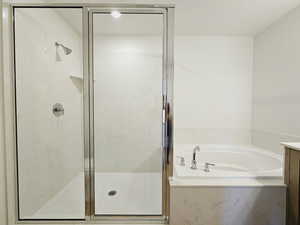 Bathroom with plus walk in shower, a textured ceiling, and vanity