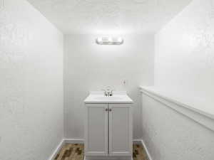 Bathroom featuring a textured ceiling, vanity, and tile patterned floors