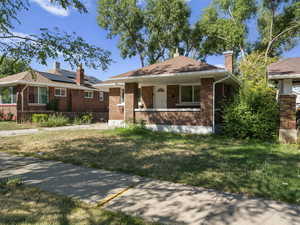 View of front facade featuring covered porch and a front yard