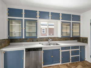 Kitchen with dishwasher, sink, and blue cabinetry