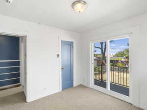 Unfurnished room with a textured ceiling and light colored carpet