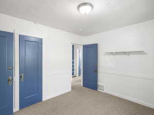 Unfurnished bedroom with a closet, a textured ceiling, and carpet