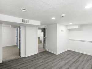 Spare room with dark hardwood / wood-style flooring and a textured ceiling