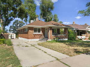 Ranch-style house with a storage shed and a front yard