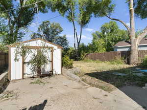 View of yard with a shed and a patio