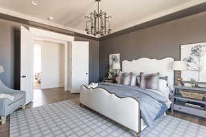 Bedroom featuring wood-type flooring and an inviting chandelier