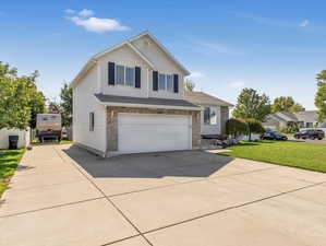 Front of property with a garage and a front lawn