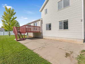 Rear view of house with a lawn, a patio, and a deck