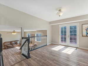 Interior space with wood-type flooring, ceiling fan, and french doors