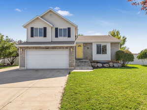 View of front of house featuring a front lawn and a garage