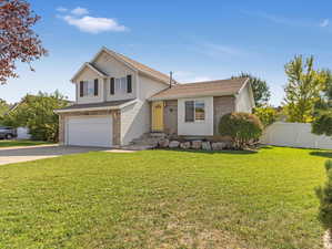 View of front of house with a garage and a front lawn