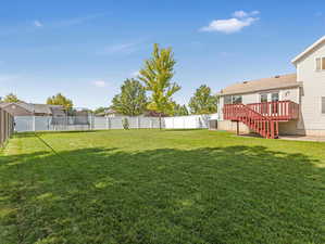 View of yard featuring a deck and a trampoline