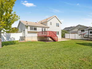 Rear view of property with a yard, cooling unit, a patio, and a deck