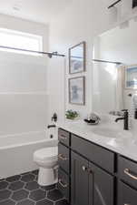 Full bathroom with toilet, vanity, and shower / bathtub combination with curtain