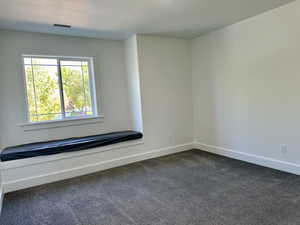 First bedroom featuring a padded window seat and a nice closet