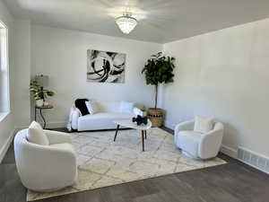 Living room with hardwood / wood-style flooring and a notable chandelier