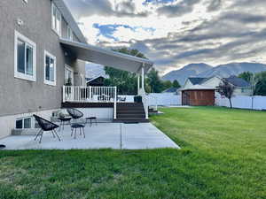 View of yard with a patio area, a deck with mountain view, and a gazebo covered hot tub