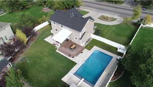 Aerial view of beautifully landscaped backyard with a sparkling pool and multiple decks