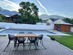 Deck featuring a mountain view, a yard, a patio, a covered hot tub and a salt water pool