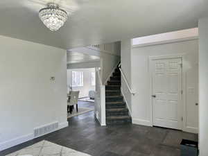 Entrance foyer featuring dark hardwood / wood-style flooring and a notable chandelier