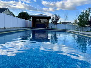 View of pool with a gazebo covering hot tub