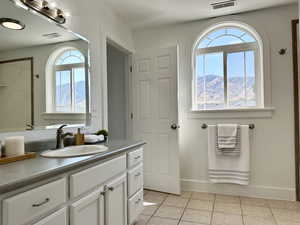 Primary Bathroom with plenty of natural light, vanity, a mountain view, and tile patterned flooring