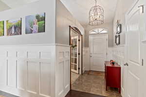 Entrance foyer featuring an inviting chandelier and wood-type flooring